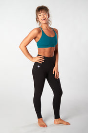 Woman facing forward smiling with hand on hip wearing black organic cotton Luana Legging yoga pants