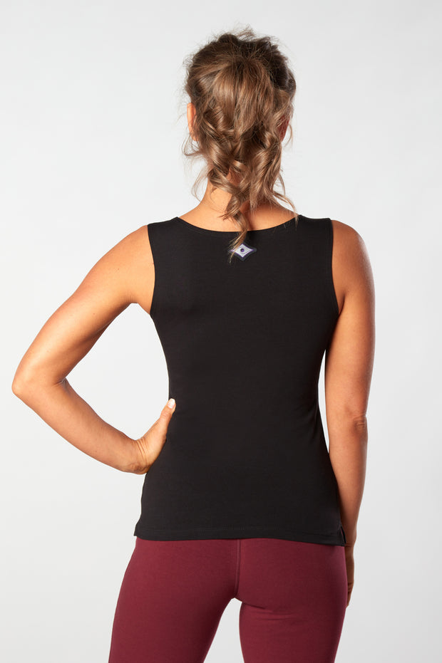 Woman facing away with hand on hip showing back of the organic cotton black Lani Top  