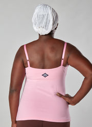 Woman showing her back with hand on hip wearing pink organic cotton Lilly Top