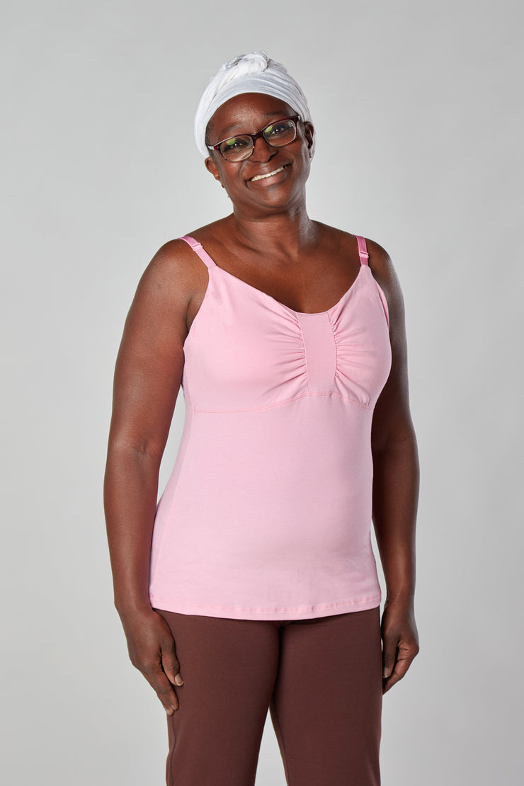 Woman smiling facing forward with hands on hips wearing pink organic cotton Lilly Top