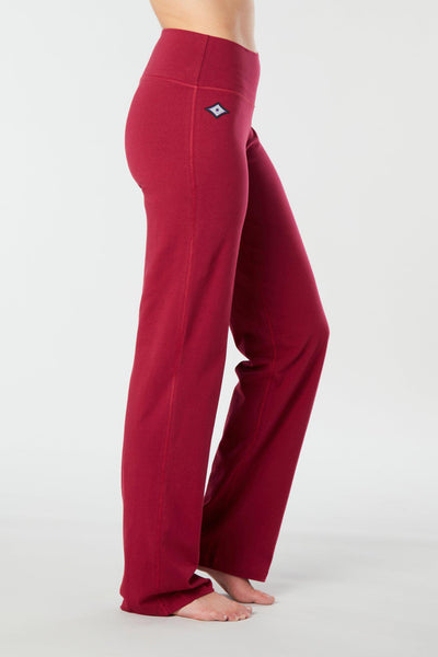 Woman's side facing legs showing pair of red organic cotton Luana Pants yoga pants