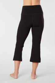Woman's lower half facing backward of her body showing black colored organic cotton Moana Capri yoga pants