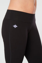 Closer view of woman's lower half facing forward of her body showing black colored organic cotton Moana Capri yoga pants