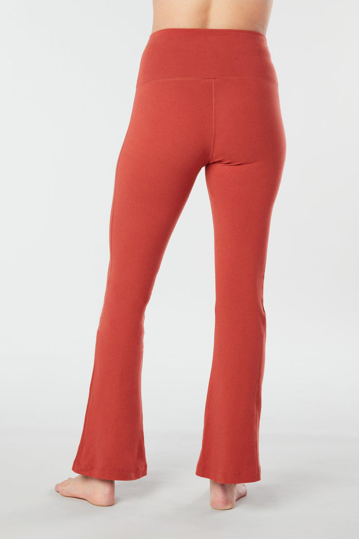 Closer view of woman's lower half facing backwards wearing cayenne colored organic cotton Moana Yoga Pants