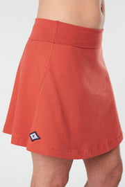 Closer front view of a woman wearing an red Kahe Skirt 