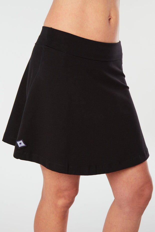 Closer front-side view of a woman wearing an black Kahe Skirt 