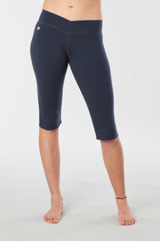 Women lower body showing legs and feet facing forward wearing dark blue colored organic cotton Pono Capri yoga pants