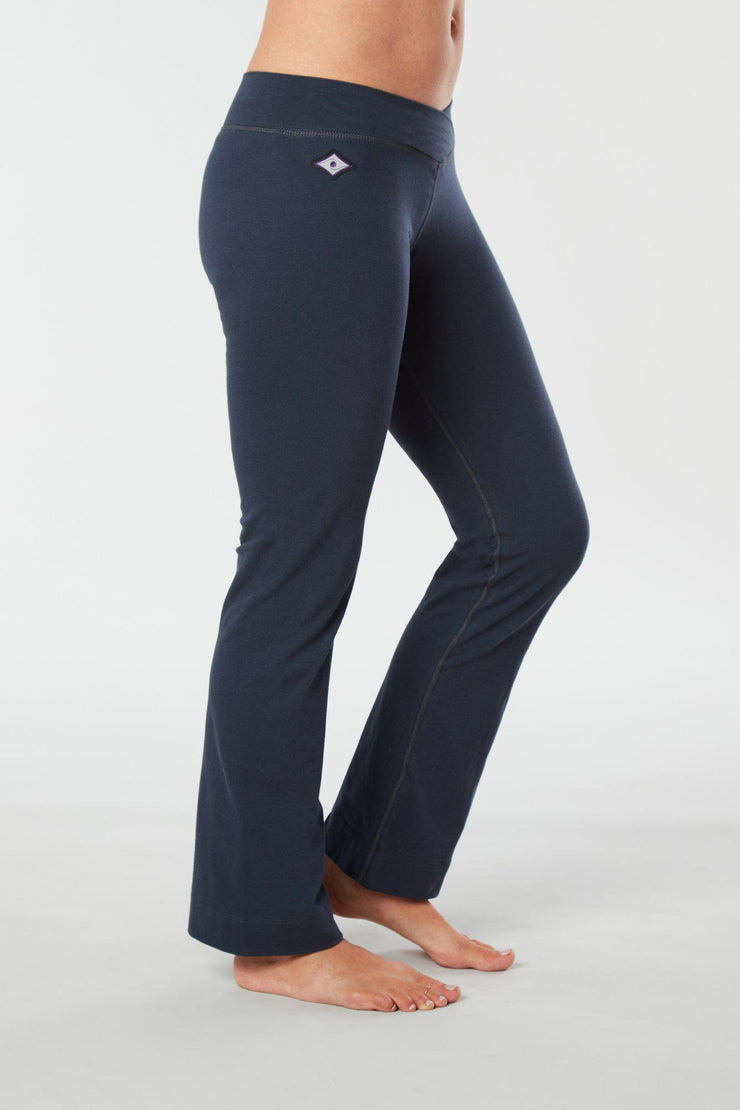 Women lower body showing legs and feet facing sideways wearing dark blue colored organic cotton Pono yoga pants
