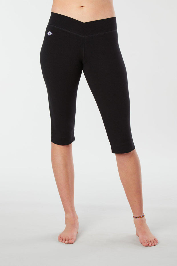 Women lower body showing legs and feet facing forwards wearing black colored organic cotton Pono Capri yoga pants
