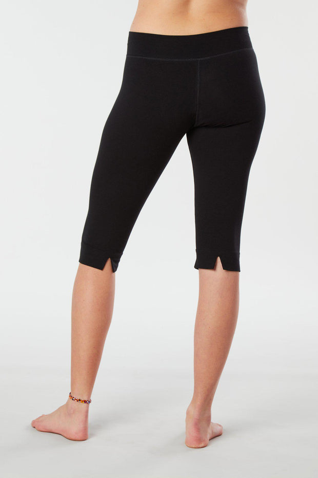 Women lower body showing legs and feet facing backwards wearing black colored organic cotton Pono Capri yoga pants