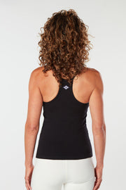 Woman facing backward with her hands at her side wearing a black colored organic cotton Mohala Camisole yoga shirt