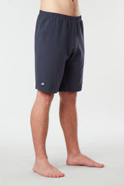 Front facing mans lower half of body wearing midnight blue colored organic cotton Mana yoga shorts