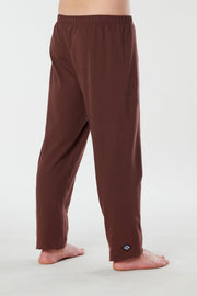 Man standing at side back view of brown colored organic cotton Mana yoga pants
