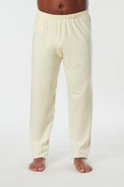 Man standing facing forward view of cream colored organic cotton Mana yoga pants