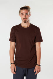 Man facing forward with arms at his side wearing dark chocolate colored organic cotton Mana Tee yoga shirt