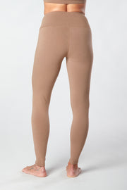 Woman facing backwards legs showing pair of tan organic cotton Luana Legging yoga pants