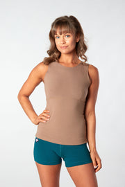 Woman facing forward with hand on hip wearing brown Lani Top and yoga shorts
