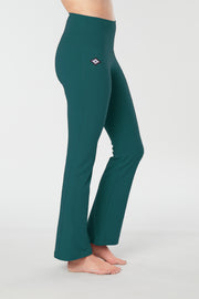 Woman's lower half facing sideways wearing teal colored organic cotton Moana Yoga Pants