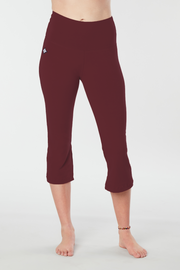 Woman's lower half facing forward of her body showing zinfandel colored organic cotton Moana Capri yoga pants