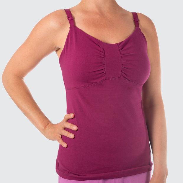 Woman torso facing forward with hands on hips wearing magenta organic cotton Lilly Top