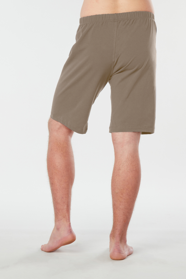 Back of mans lower half of body wearing caribou colored organic cotton Mana yoga shorts