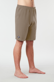 Front facing mans lower half of body wearing caribou colored organic cotton Mana yoga shorts