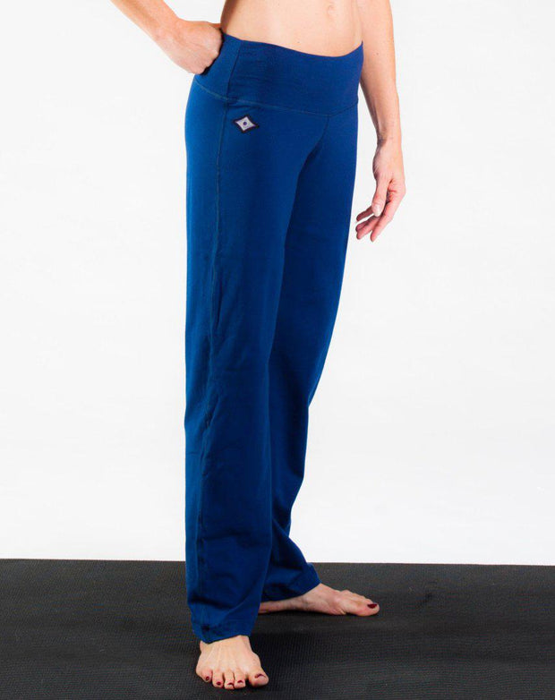 Woman's side facing legs showing pair of electric blue colored organic cotton Luana Pants yoga pants