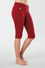 Women lower body showing legs and feet facing sideways wearing red colored organic cotton Pono Capri yoga pants